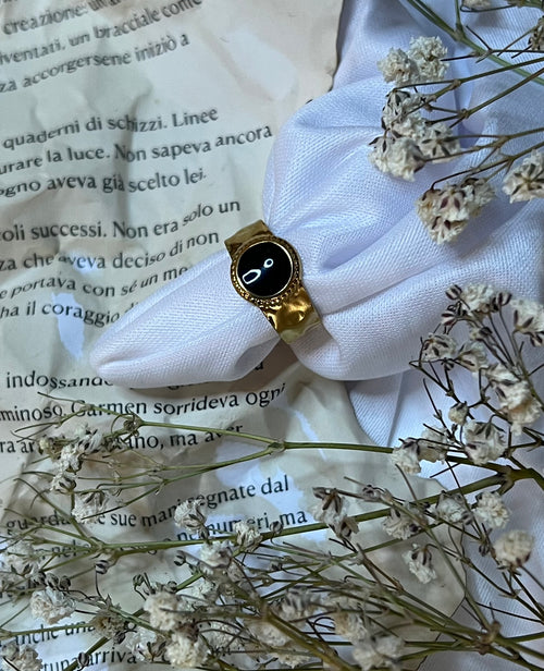 Anello in acciaio inossidabile placcato oro 18k con finitura regolabile e dettagli smalatati neri. La combinazione di materiali nobili garantisce durabilità e resistenza nel tempo, mentre la placcatura in oro 18k assicura un aspetto lussuoso e raffinato. I dettagli smalatati neri aggiungono carattere e contrasto elegante. La struttura regolabile si adatta a diverse misure, offrendo versatilità e comfort di indosso quotidiano. Perfetto per chi ricerca un accessorio moderno che unisce qualità costruttiva e de